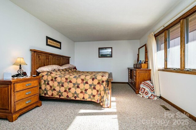 bedroom featuring light colored carpet and baseboards