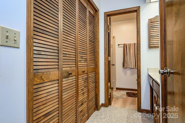 corridor with wood finished floors and baseboards