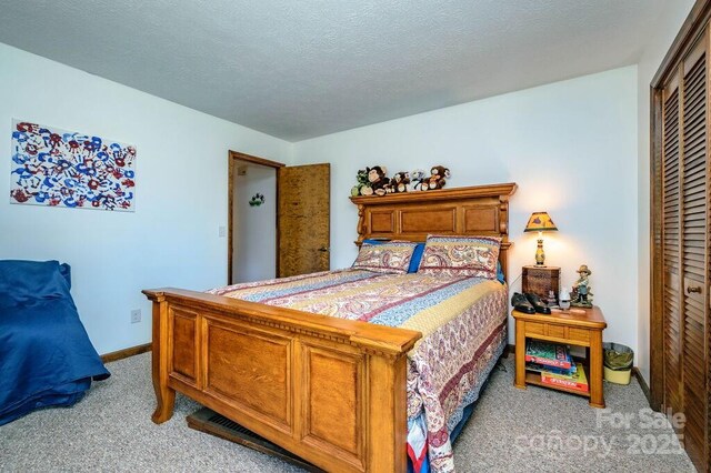 bedroom featuring light colored carpet, a closet, baseboards, and a textured ceiling