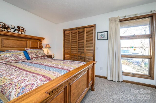 bedroom with light colored carpet, baseboards, and a closet