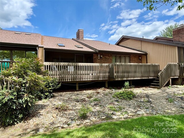 rear view of house with a chimney and a deck