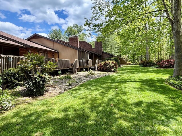 view of grassy yard featuring a wooden deck
