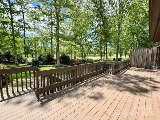 wooden deck with view of wooded area