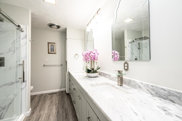 3520 4th Street Blvd NW, Hickory, NC 28601 - bathroom with a marble finish shower, double vanity, toilet, wood finished floors, and a textured ceiling