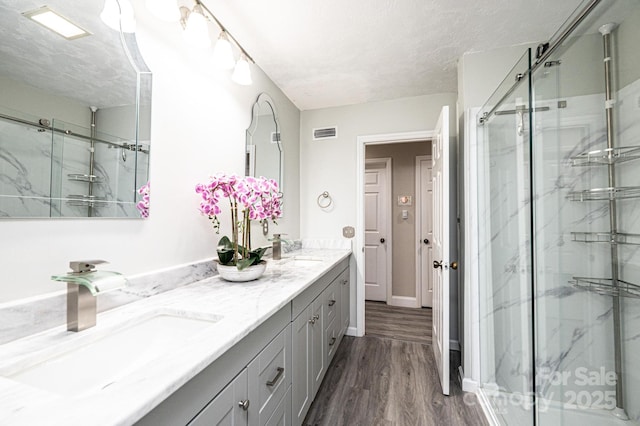 3520 4th Street Blvd NW, Hickory, NC 28601 - full bathroom with a marble finish shower, wood finished floors, double vanity, a textured ceiling, and baseboards