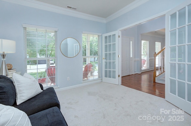 sitting room featuring ornamental molding, french doors, plenty of natural light, carpet, and stairway
