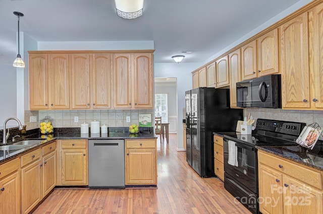 kitchen featuring black appliances, a sink, light brown cabinetry, and backsplash