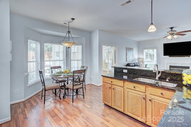 kitchen featuring a sink, light brown cabinets, healthy amount of natural light, and open floor plan