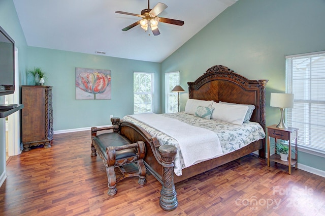 bedroom with multiple windows, baseboards, wood finished floors, high vaulted ceiling, and ceiling fan