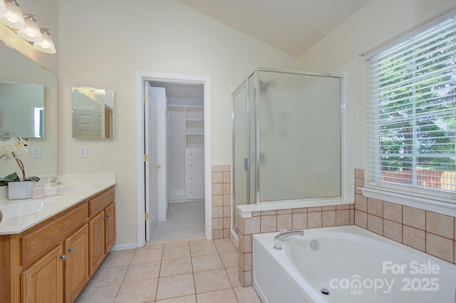 bathroom featuring tile patterned floors, a shower stall, a garden tub, lofted ceiling, and double vanity