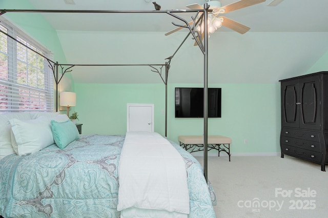 carpeted bedroom with vaulted ceiling, baseboards, and ceiling fan