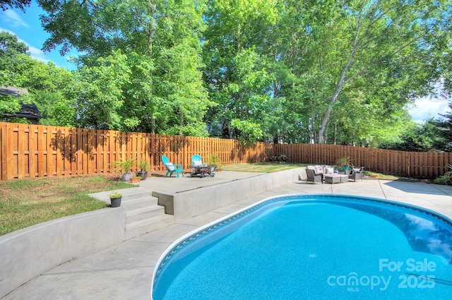 view of swimming pool featuring a patio area, a fenced backyard, an outdoor hangout area, and view of scattered trees