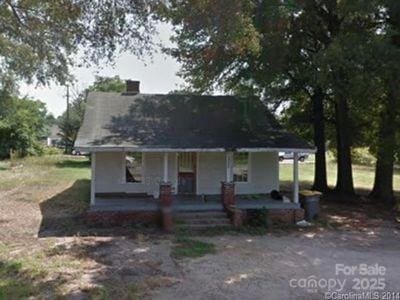 view of front of home featuring a chimney and a porch