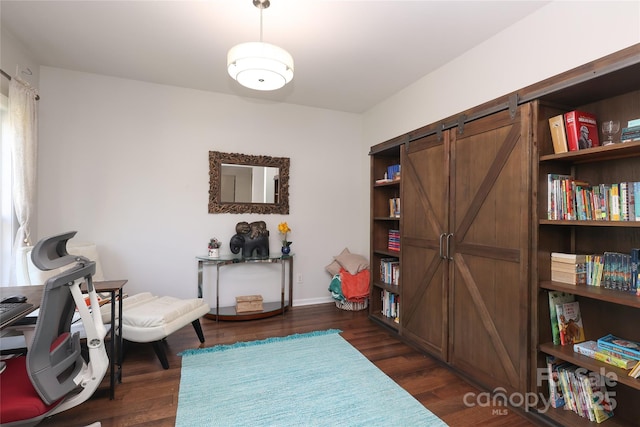 10217 Falling Leaf Dr, Concord, NC 28027 - sitting room with a barn door, dark wood finished floors, and baseboards
