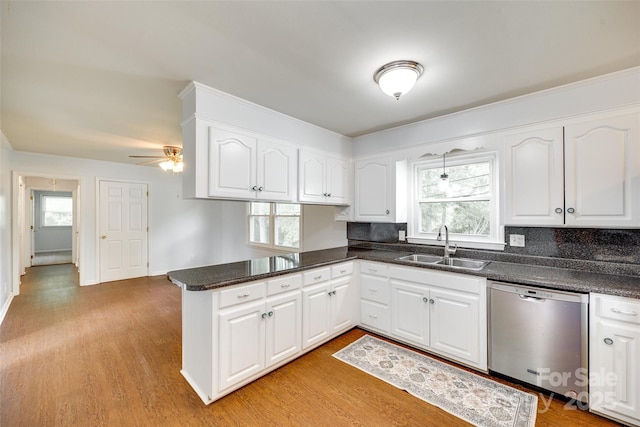 kitchen with dishwasher, a sink, plenty of natural light, and a peninsula