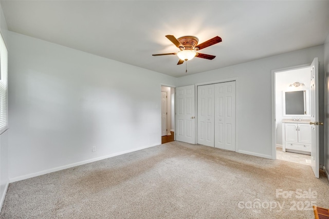 unfurnished bedroom featuring carpet, baseboards, a closet, and ensuite bathroom