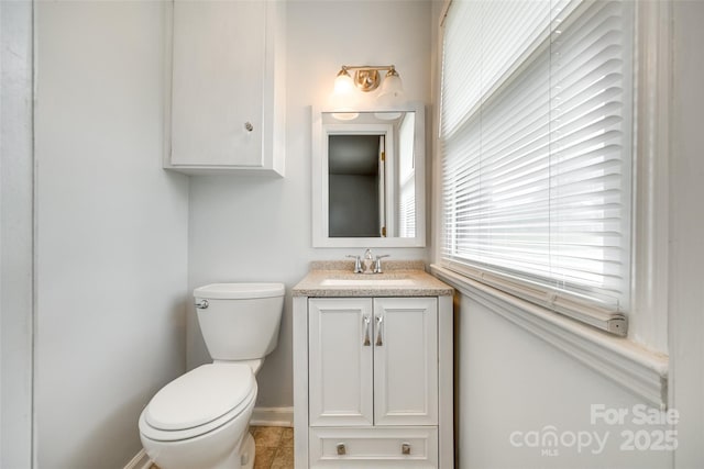 bathroom featuring baseboards, vanity, and toilet