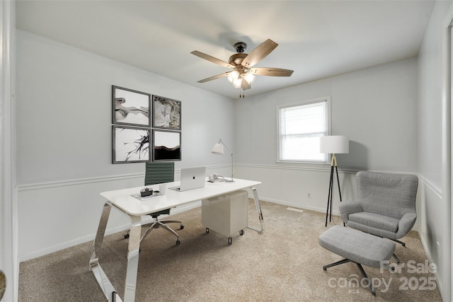 office space featuring light carpet, ceiling fan, and baseboards