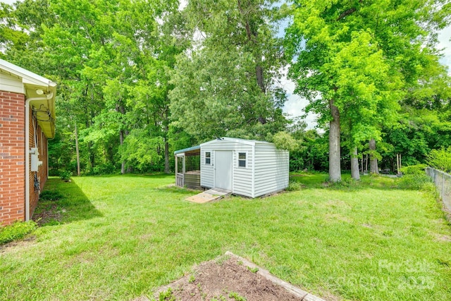 view of yard with an outbuilding, a storage shed, and view of wooded area