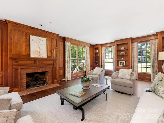 living room with light wood-style floors, a fireplace, recessed lighting, and built in features