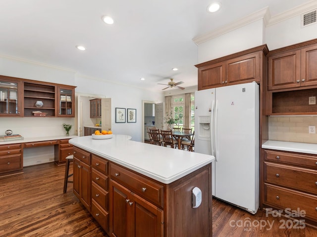 kitchen with white fridge with ice dispenser, open shelves, crown molding, a kitchen island, and a ceiling fan