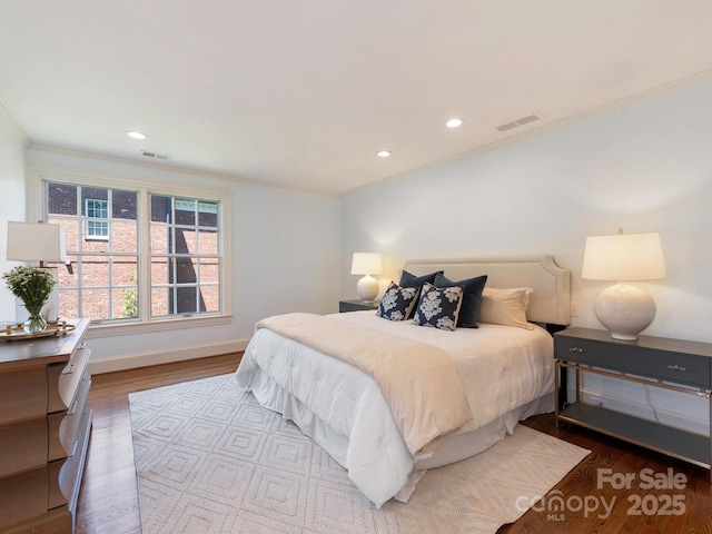 bedroom featuring ornamental molding, wood finished floors, baseboards, and recessed lighting