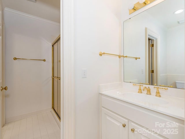 full bathroom featuring a stall shower, vanity, crown molding, tile patterned flooring, and baseboards