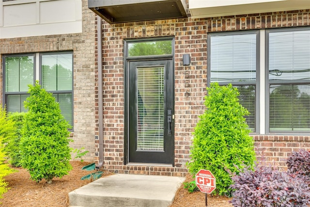 view of exterior entry with brick siding