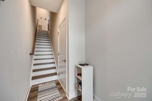 stairway with baseboards and wood finished floors