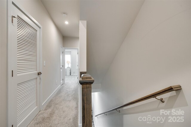 hallway featuring carpet floors, baseboards, and recessed lighting