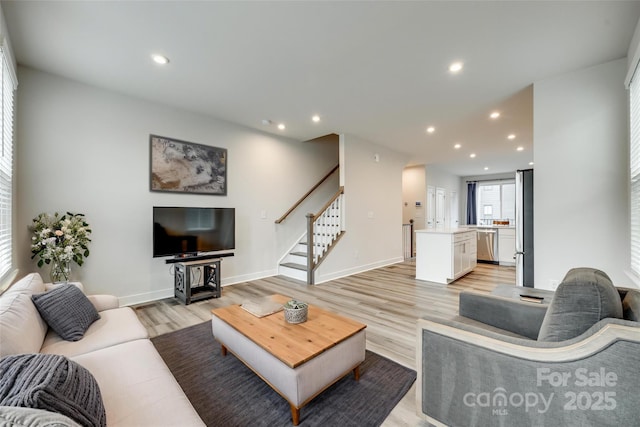 living room featuring stairway, light wood finished floors, recessed lighting, and baseboards
