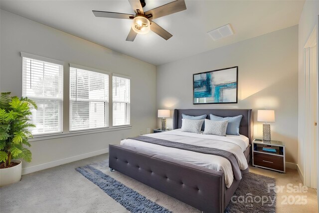 bedroom featuring light colored carpet, baseboards, and a ceiling fan
