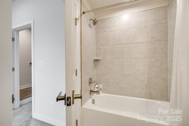 bathroom with shower / bathtub combination with curtain and baseboards