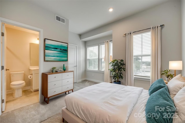 bedroom with light colored carpet, connected bathroom, baseboards, and recessed lighting