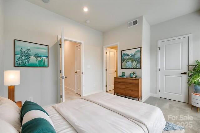 bedroom with light colored carpet and baseboards