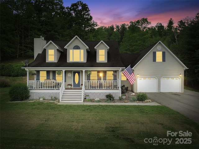 view of front facade featuring covered porch, an attached garage, a chimney, a front yard, and driveway