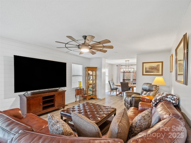 living room featuring light wood-style floors and ceiling fan with notable chandelier