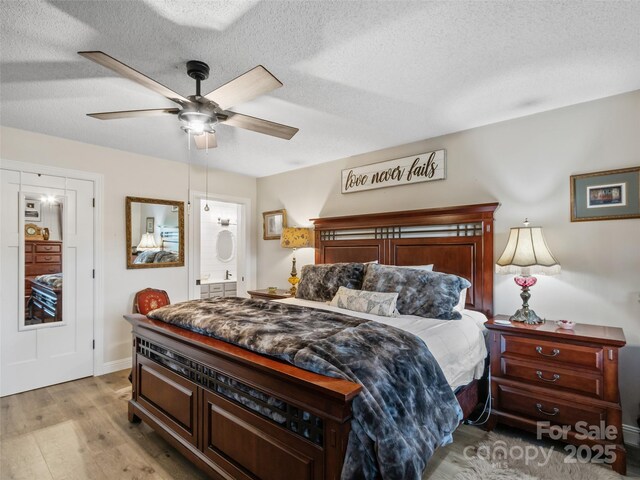 bedroom featuring light wood finished floors, a textured ceiling, and ensuite bathroom