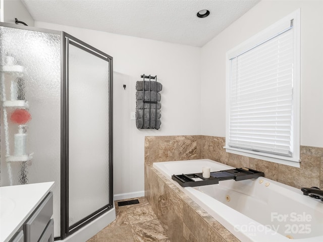 full bath featuring a garden tub, a textured ceiling, visible vents, a shower stall, and vanity