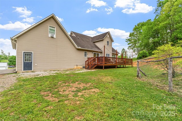 rear view of property with a yard and a wooden deck