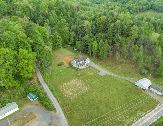 drone / aerial view with a wooded view