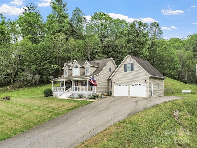 new england style home featuring covered porch, driveway, a garage, and a front yard