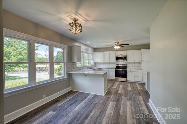 417 Mountain View Ave SE, Valdese, NC 28690 - kitchen featuring stainless steel appliances, a sink, a peninsula, backsplash, and dark wood-type flooring