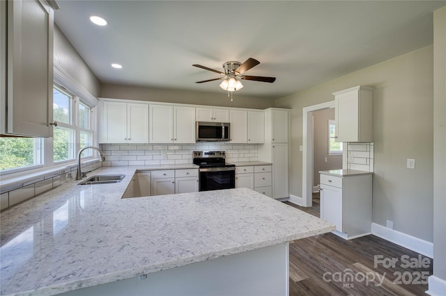 417 Mountain View Ave SE, Valdese, NC 28690 - kitchen with stainless steel appliances, a sink, tasteful backsplash, a ceiling fan, and dark wood finished floors