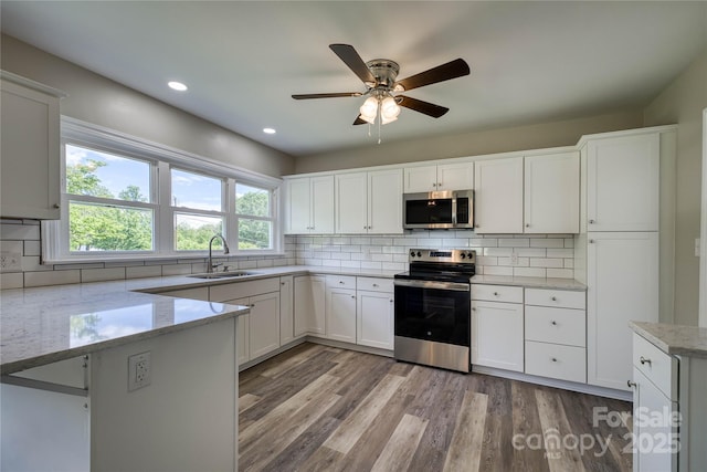 417 Mountain View Ave SE, Valdese, NC 28690 - kitchen with appliances with stainless steel finishes, a sink, white cabinets, ceiling fan, and decorative backsplash
