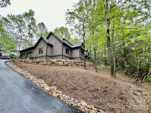 view of side of home featuring an attached garage