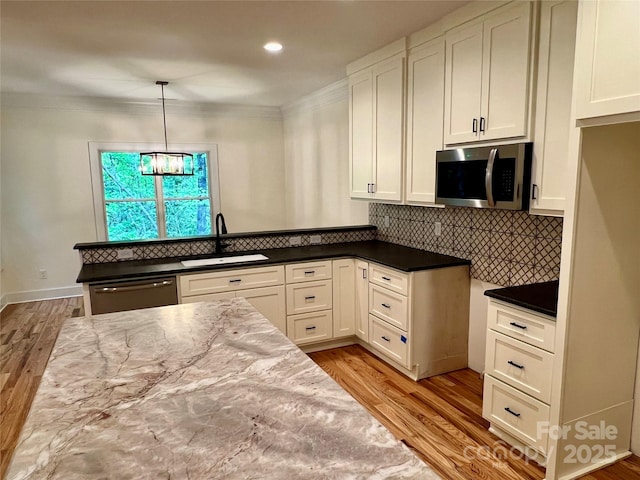 kitchen with a sink, stainless steel microwave, dishwashing machine, wood finished floors, and crown molding