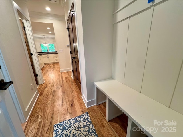 mudroom featuring light wood-type flooring, ornamental molding, baseboards, and recessed lighting