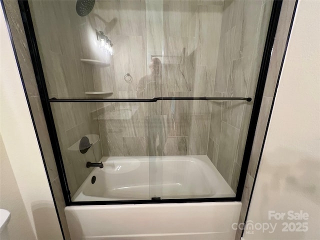 bathroom featuring shower / bath combination with glass door and toilet