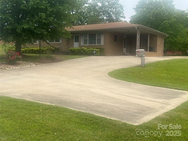 view of front of house with a front lawn, driveway, brick siding, and a carport